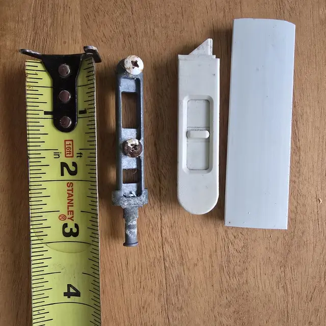 Window hardware parts laid out with a tape measure for sizing